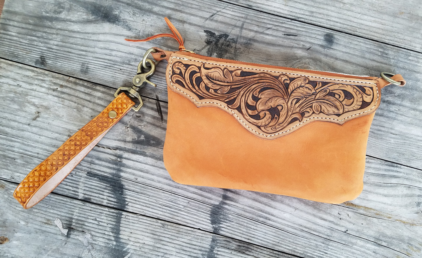 Hand tooled leather wristlet with orange chap leather body