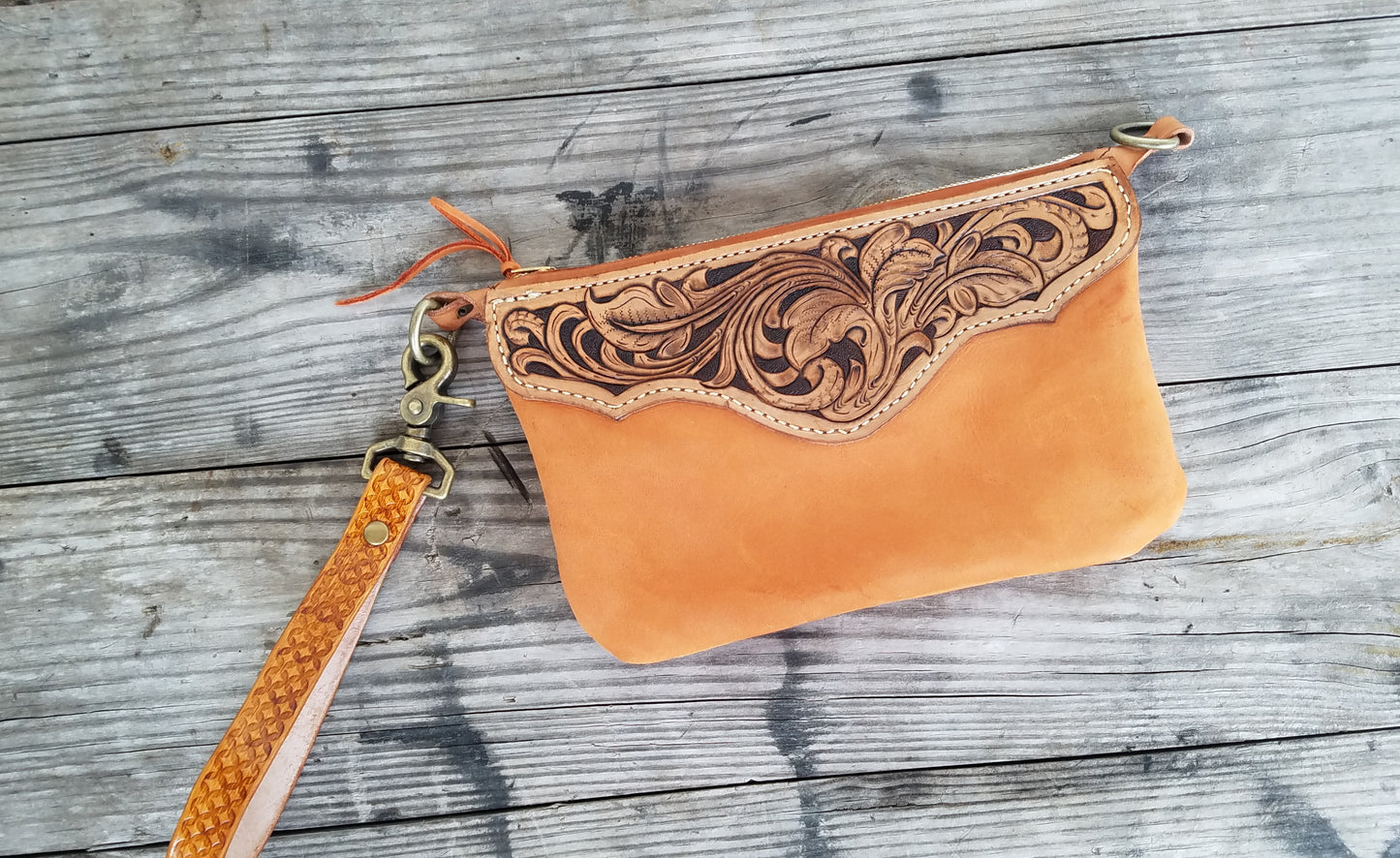 Hand tooled leather wristlet with orange chap leather body